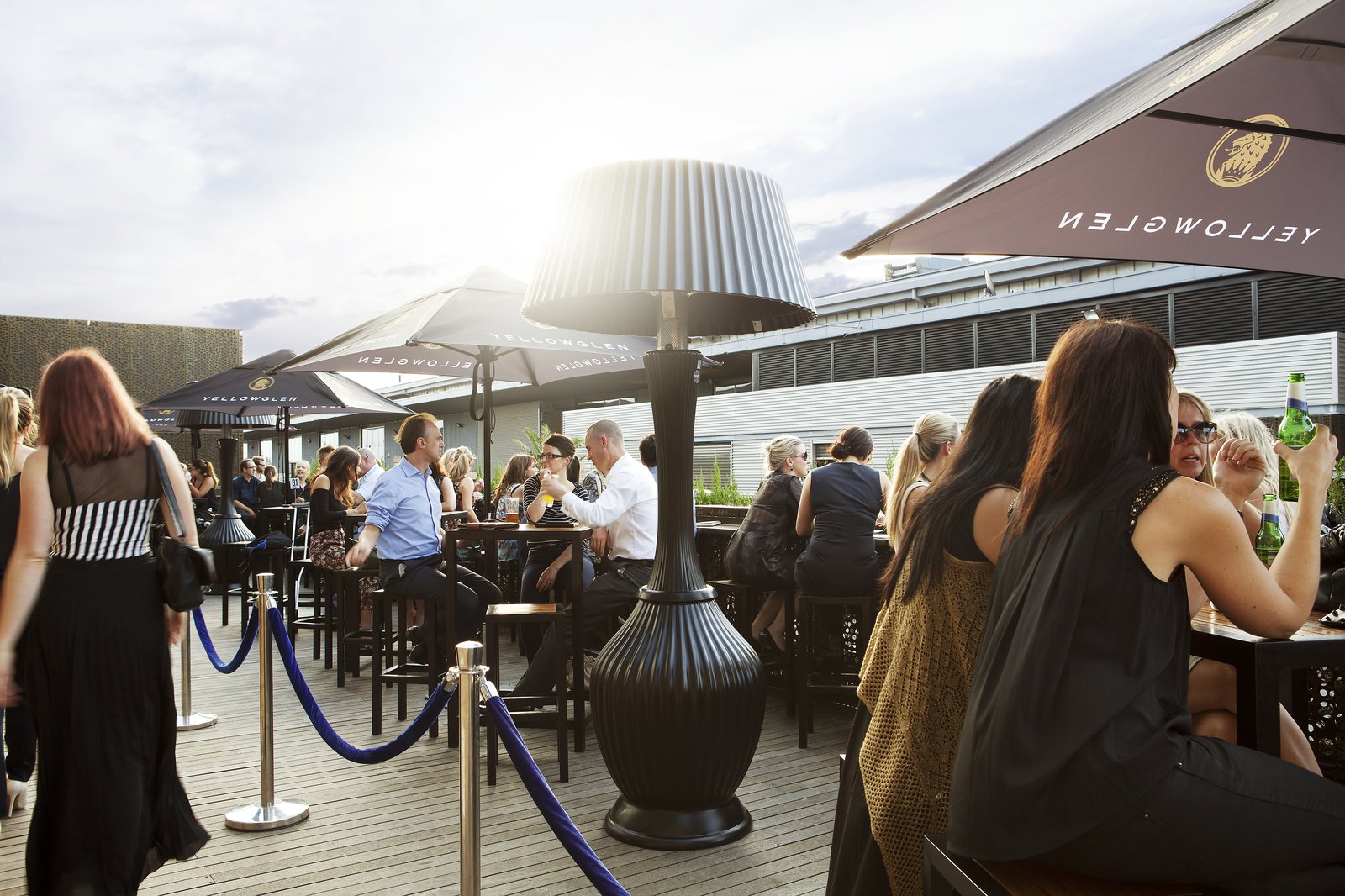 Guests gathered on a rooftop deck around a Kindle heater lamp at golden hour